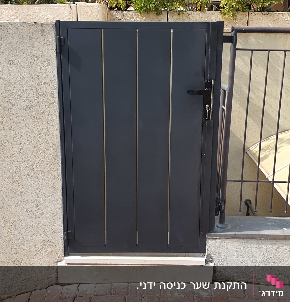 שער מתכת שחור עם פסים אנכיים על רקע קיר בטון